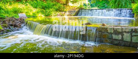 Kleiner doppelter Wasserfall am Waldbach. Gaden Steinschleuder in ruhiger Waldstimmung. Stockfoto