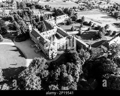 Schloss Sychrov bei Sonnenuntergang, Tschechische Republik. Luftaufnahme von der Drohne. Schwarzweißbild. Stockfoto