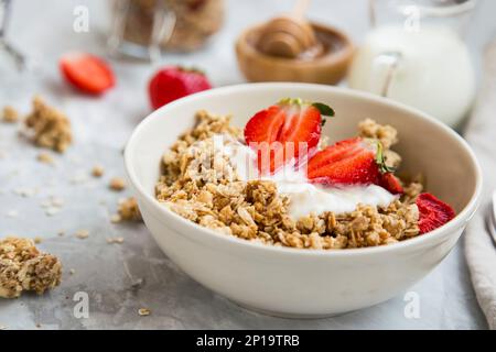 Müsli, Haferschale mit Joghurt und Erdbeeren, gesundes Frühstück mit Müsli, Joghurt und Obst Stockfoto