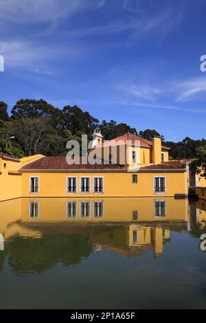 Portugal, Lissabon, Oeiras. Historische Schießpulverfabrik. Die Villa spiegelt sich im Gartenteich vor einem tiefen blauen Himmel mit Zirruswolken wider Stockfoto