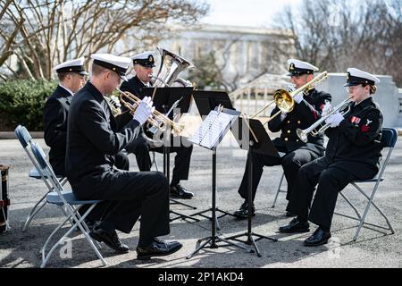 Navy Band Ceremonial Brass Ensemble spielt während einer Zeremonie anlässlich des 125. Jahrestages des Untergangs der USS Maine, Arlington National Cemetery, Arlington, Virginia, 15. Februar, 2023. Am 15. Februar 1898 explodierte die USS Maine vor der Küste von Havanna, Kuba, und 260 ihrer Crew gingen verloren. Aufgrund der spanischen Politik mussten die Beerdigungen innerhalb von 24 Stunden erfolgen, daher wurde die erste Besatzung, die nach der Katastrophe wieder aufgefunden wurde, auf dem Colon Friedhof in Havanna begraben. Am 30. März 1898 genehmigte der Kongress einen Gesetzentwurf, der die Entwaffnung und Übertragung ihrer Überreste an ANC genehmigte. Ein Stockfoto