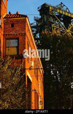 Das Stahlwerk der alten Eagle Avenue-Liftbrücke ragt über einer alten Backsteinfeuerwache im Viertel Flats in Cleveland, Ohio. Stockfoto