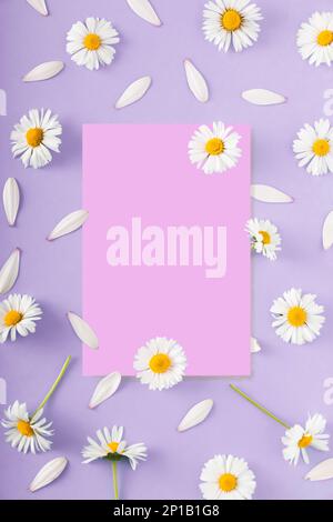 Ein farbenfrohes Bild mit einem quadratischen Papierbogen für zusätzlichen Text, umgeben von leuchtenden violetten und weißen Blumen Stockfoto