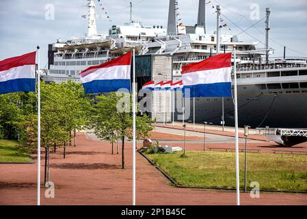 Rotterdam Niederlande – 31. Mai 2019, Blick auf Rotterdams berühmtes Hotel und das alte Schiff SS Rotterdam mit einer niederländischen Flagge im Vordergrund Stockfoto