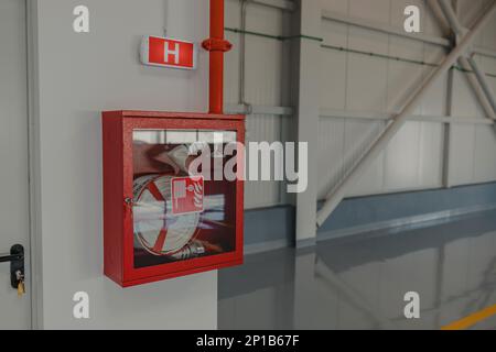 Feuerlöschschlauch-Schrank im Gebäude und Lichtsignal Stockfoto