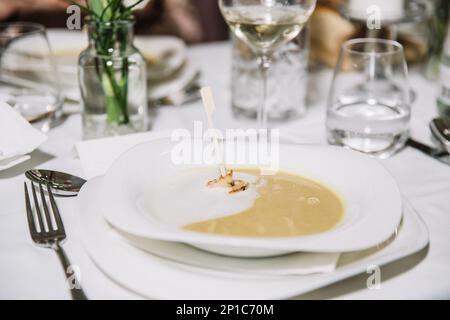 Cremige Kürbissuppe mit Sahne Sauce und gegrillten Garnelen, Restaurant-Konzept, Feier Stockfoto