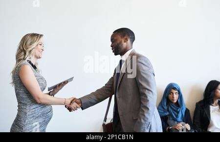 Es ist so gut, Sie endlich zu treffen. Aufnahme eines gut gekleideten Kandidaten, der vor einem Interview mit seinem Interviewer die Hände schüttelt. Stockfoto