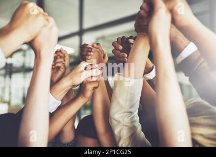 Gemeinsam können wir alles tun. Ausgeschnittene Aufnahme einer Gruppe von Geschäftsleuten, die sich die Hände hielten. Stockfoto