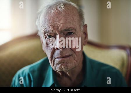 Ich bin jetzt alle zerknittert und mürrisch. Ausgeschnittene Aufnahme eines älteren Mannes, der allein in einem Wohnzimmer sitzt. Stockfoto