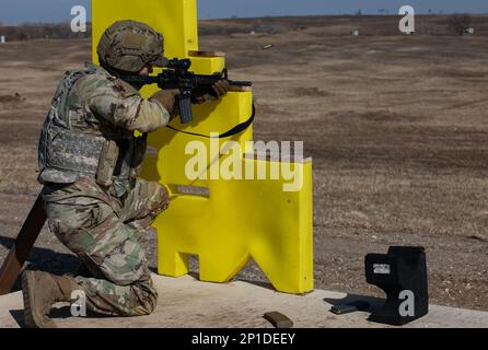 USA Army Staff Sgt. Jacob T. Kunst, ein Spezialist für die Beseitigung von Sprengstoffen, der der 797. Ordnance Company, dem 79. EOD-Bataillon, der 71. Ordnance Group, zugewiesen wurde, feuert seinen M4A1 in der knienden Position auf Reichweite 1 in Fort Riley, Kansas, am 6. Februar 2023 ab. Kunst nahm am EOD-Wettbewerb 79. Teil. „Team des Jahres“-Wettbewerb, ein Wettbewerb, bei dem die EOD-Soldaten ihre fachspezifischen Fähigkeiten unter Beweis stellen und sich im März für die Teilnahme am Wettbewerb „Team des Jahres“ der EOD-Gruppe 71. qualifizieren. Stockfoto