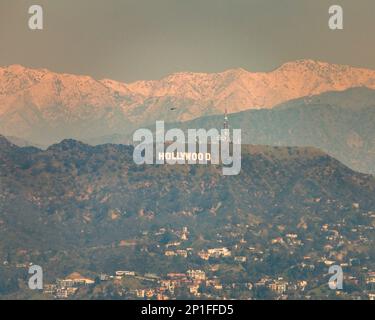 3. März 2023, Los Angeles, CA, USA: Ein verschwommener Blick auf das Hollywood-Schild mit schneebedeckten Bergen dahinter in Los Angeles, CA. Stockfoto