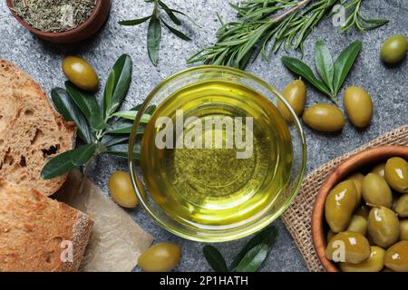 Flache Liegezusammensetzung mit Olivenöl auf grauem Tisch, flache Liege Stockfoto