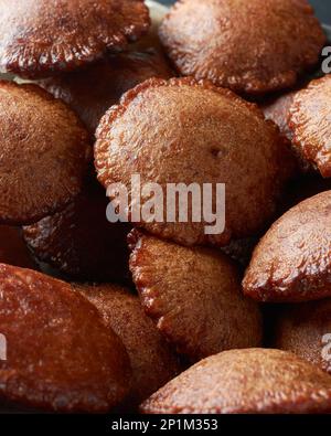 Nahaufnahme von frittiertem sri-lankischem Süßigkeiten namens Kevum oder Kavum, einem Haufen traditioneller Desserts aus Reismehl und Palmzucker oder Kithul-Zucker Stockfoto