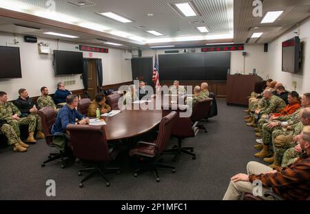 Cmdr. Douglas Kennedy, Stabschef des Befehlshabers, Fleet Activities Sasebo (CFAS), spricht bei einer Nachbesprechung der Regionalen Bewertung (RASS) der Anlage am 16. Februar 2023 vor einem Bewertungsteam des Befehlshabers der Navy Region Japan und des Personals der Sicherheitsabteilung der CFAS. RASS ist Teil des Ausbildungszyklus und der Zeugniserteilung für die Marine Security Force (CNIC) von Commander, Navy Installations Command, in dem die Reaktionsfähigkeit und Einsatzbereitschaft der Sicherheitskräfte einer Anlage geprüft wird. Stockfoto