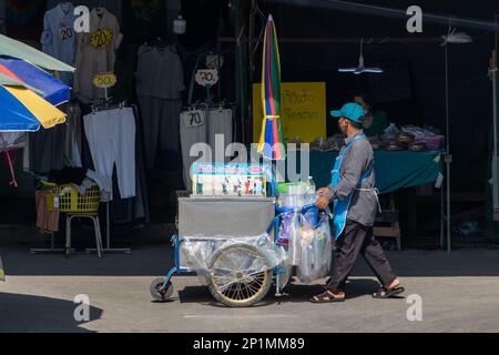 SAMUT PRAKAN, THAILAND, FEBRUAR 13 2023, Ein Verkäufer schiebt einen mobilen Verkaufsautomaten mit gekühlten Getränken Stockfoto