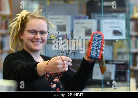 02. März 2023, Sachsen-Anhalt, Halle (Saale): Bibliotheksangestellte Sara Schumann zeigt eine Auswahl an Stricknadeln, die zu den am häufigsten ausgeliehenen Artikeln gehören. Neben viel Literatur können auch Gegenstände aus einer „Bibliothek der Dinge“ in der Stadtbibliothek Halle (Saale) ausgeliehen werden. Das sind Dinge, die nicht immer benutzt werden. Um Kosten zu sparen und die Umwelt zu schützen, müssen diese Artikel nicht von jedem gekauft werden, sondern können für einen Zeitraum von vier Wochen ausgeliehen werden. Foto: Heiko Rebsch/dpa Stockfoto