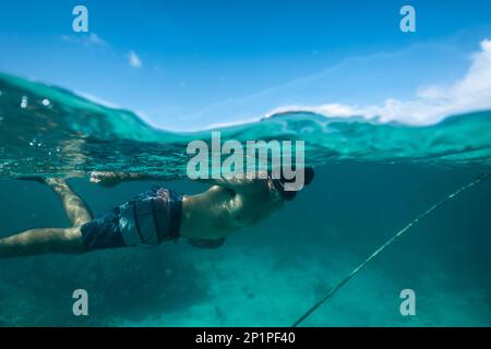 Providenciales, Turks- und Caicos-Inseln - März 3 2023: Ein Schnorchler/Taucher erkundet die Korallenköpfe am Smith's Reef, einem beliebten Ort zum Schnorcheln. Stockfoto