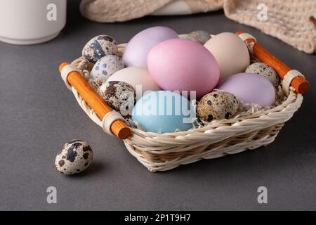 Korb mit ostereiern auf grauem Hintergrund Stockfoto