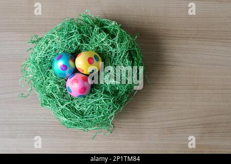 Blick von oben auf die drei gepunktet Ostern Eier in einem Nest aus Kunstgras Dekoration auf Tabelle mit Kopie Raum Stockfoto