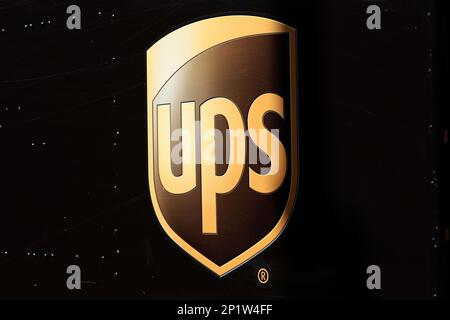 United Postal Service, UPS Markenlogo in goldenen Buchstaben auf braunem Lieferwagen Stockfoto