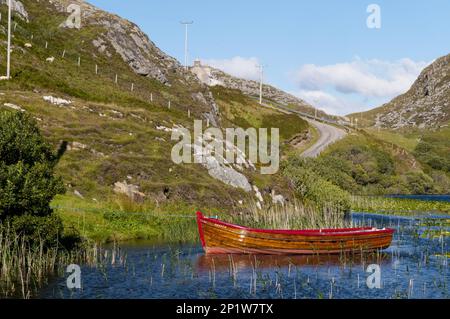 Blick auf das Ruderboot am süßwasserloch, Loch Dubh, Tarbet, Sutherland, Highlands, Schottland, Vereinigtes Königreich Stockfoto