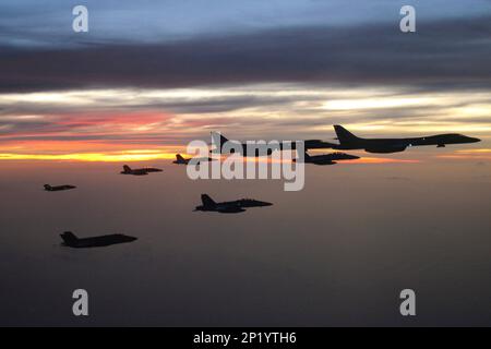 Südchinesisches Meer. 17. Februar 2023. F/A-18 Super Hornets aus den „Fighting Redcocks“ des Strike Fighter Squadron (VFA) 22, ein F/A-18F Super Hornet aus den „Mighty Shrikes“ des Strike Fighter Squadron (VFA) 94, ein E/A-18G Growler aus dem „Cougars“ des Electronic Attack Squadron (VAQ) 139, F-35B, die IIS aus den „Flying Leathernecks“ der Marine Strike Fighter Squadron (VMFA) 122 und Air Force B-1B Lancers aus dem 34. Expeditionary Bomb Squadron (34. EBS) fliegen in Formation während einer gemeinsamen Übung für alle Bereiche und demonstrieren einzigartige, theaterweite, multidisziplinäre High-End-Kampfhandlungen Stockfoto