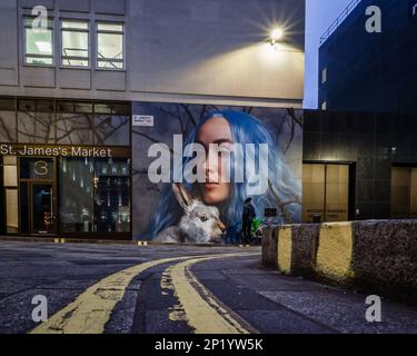 Eine Beobachterin von Claire Luxtons Fotoinstallation „Winter's Breath“ in Londons St. James's Market in Piccadilly. Stockfoto