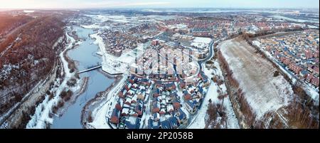 Luftdrohne. Ebbsfleet Garden City in Kent, im Dezember 2022 von Schnee bedeckt. Neubauten und gefrorener See entlang der Autobahn A2. Stockfoto