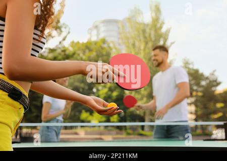 Freunde, die im Freien Tischtennis spielen, konzentrieren sich auf die Hände Stockfoto