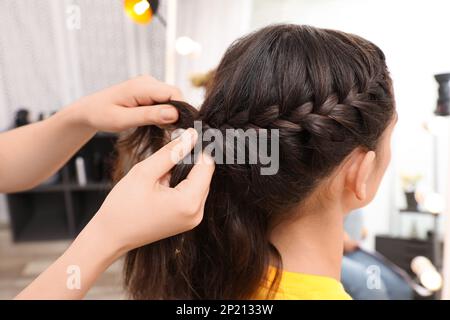 Professionelles Stylist-Flechten der Haare des Kunden im Salon Stockfoto