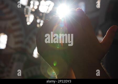 Islamisches Foto. Muslimischer Mann betet mit erhobenen Händen und direktem Sonnenlicht. Ramadan oder islamic oder Laylat al-qadr oder kadir gecesi Konzeptfoto. Selektiv Stockfoto