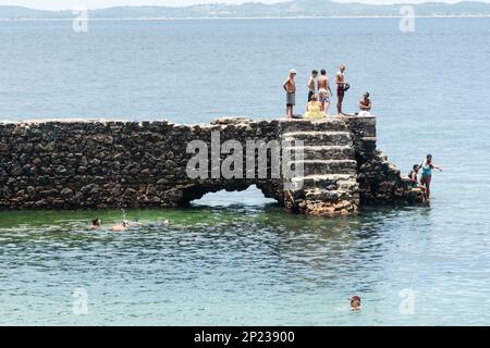 Salvador, Bahia, Brasilien - 14. Januar 2022: Menschen springen vom Pier von Forte de Santa Maria am Strand Porto da Barra in Salvado ins Wasser Stockfoto