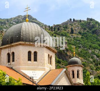 Kuppeln der Nikolaikirche mit Kotor-Stadtmauer im Berghang im Hintergrund Stockfoto