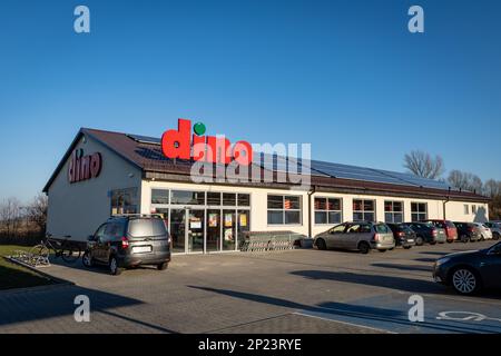 Tyniec Maly, Polen - 9. Februar 2023: Eingang Dino Food Store mit rotem Firmenlogo. Stockfoto
