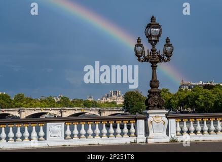 Brücke Pont Alexandre III über die seine mit farbenfrohem Regenbogen in Paris, Frankreich Stockfoto