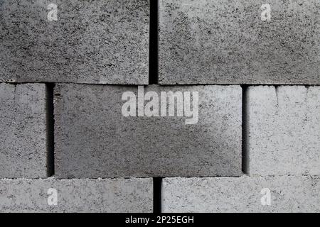 Graue Bausteine aus Zement, gestapelt, Nahhintergrund. Viele große Betonsteine stapeln die Textur Stockfoto