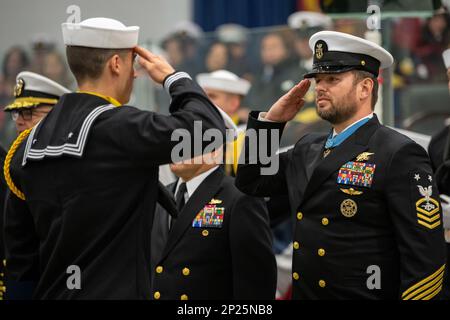 Der pensionierte Master Chief Special Warfare Operator Edward Byers, der mit einer Ehrenmedaille ausgezeichnet wurde, grüßt einen Recruit Award-Gewinner während einer Abschlusszeremonie zur Pass-in-Review am Recruit Training Command. Mehr als 40.000 Rekruten trainieren jährlich im einzigen Boot-Camp der Navy. Stockfoto