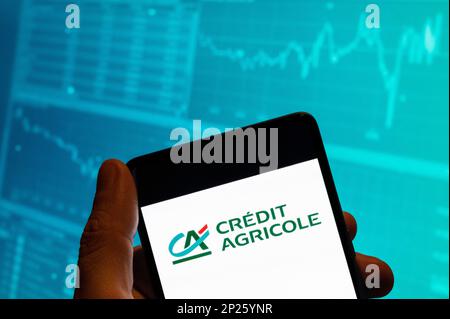 China. 15. Februar 2023. In dieser Fotoabbildung wird das Logo des größten Finanzgenossenschaftsinstituts der französischen Welt Credit Agricole auf einem Smartphone mit einer Grafik des Börsenindex im Hintergrund angezeigt. (Kreditbild: © Budrul Chukrut/SOPA Images via ZUMA Press Wire) NUR REDAKTIONELLE VERWENDUNG! Nicht für den kommerziellen GEBRAUCH! Stockfoto