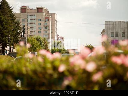 Russische Stadt Khabarowsk mit Blumen im Stadtzentrum. Skulptur Vladimir Lenin auf einer Hauptstadtstraße im Sommer. Lenin-Denkmal von M. man Stockfoto