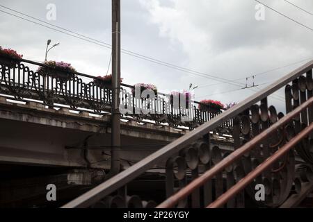 Kreuzung mit verzierten Geländer und Blumen dekoriert. Schöne Verkehr Überführung an einem bewölkten Tag Hintergrund Stockfoto