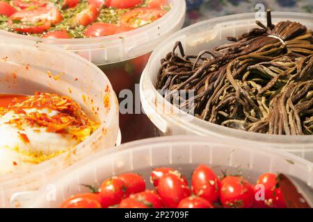 Verschiedene eingelegte Salate bei einem russischen Essen Marktstand. Verschiedene mariniertes Gemüse in Eimern zum Verkauf - Farn, Tomaten, Kohl Stockfoto