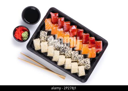 Sushi-Set mit Wasabi, Ingwer und Sojasoße, serviert in einer Plastikbox zum Mitnehmen. Gemischtes japanisches Sushi mit Thunfisch, Lachs, Sesam isoliert auf WH Stockfoto