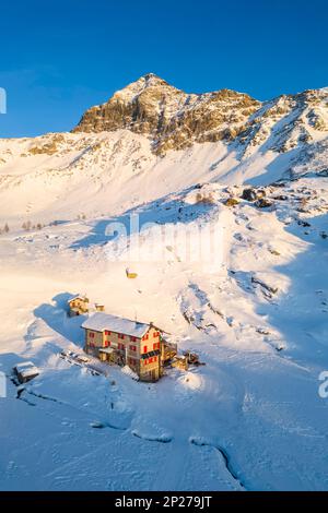 Sonnenuntergang vor Rifugio Cristina und Pizzo Scalino im Winter. Lanzada, Valmalenco, Valtellina, Sondrio District, Lombardei, Italien, Europa. Stockfoto