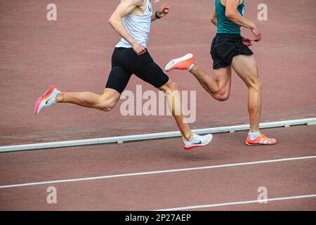 Chelyabinsk, Russland - 5. Juni 2022: Zwei männliche Läufer in Spikes Schuhen Nike und Adidas laufen während der UFD Athletics Champions auf mittleren Distanzen im Stadion Stockfoto