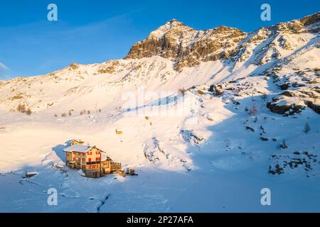 Sonnenuntergang vor Rifugio Cristina und Pizzo Scalino im Winter. Lanzada, Valmalenco, Valtellina, Sondrio District, Lombardei, Italien, Europa. Stockfoto