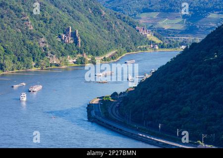 Trechtingshausen: Rhein (Rhein), Schiffe, Schloss Rheinstein (Vorderseite), Schloss Reichenstein (Rückseite), Ostrheinbahn, Zug in Rheintal, Rheinland... Stockfoto