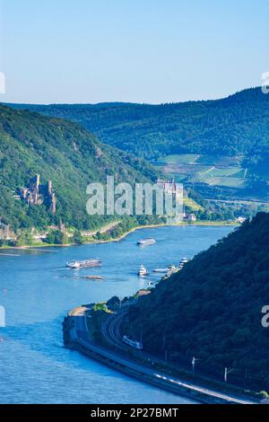 Trechtingshausen: Rhein (Rhein), Schiffe, Schloss Rheinstein (Vorderseite), Schloss Reichenstein (Rückseite), Ostrheinbahn, Zug in Rheintal, Rheinland... Stockfoto