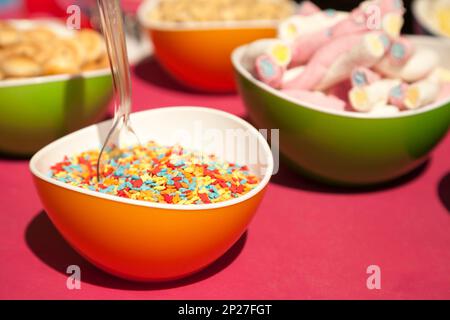 Streusel, Marshmallows und andere Süßwaren in hellen Schalen.  Lustige bunte Nahaufnahme von verschiedenen Arten von Süßigkeiten. Leckere Snacks Proben im Candy shop Stockfoto