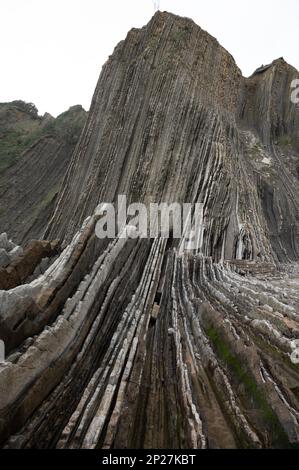 Blick auf steil geneigte Schichten von Flysch-geologischer Formation an der Atlantikküste bei Zumaia bei Ebbe, Baskenland, Spanien Stockfoto