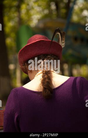 Khabarowsk, Russland - 11. Juni 2017: Junge kaukasische Frau in historischem Kostüm - violettes Kleid aus Filz und roter Tiroler Hut mit Federn. Wunderschönes La Stockfoto